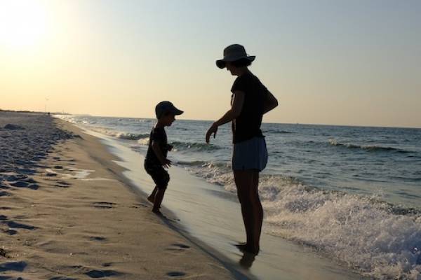 mom and child on beach sunrise