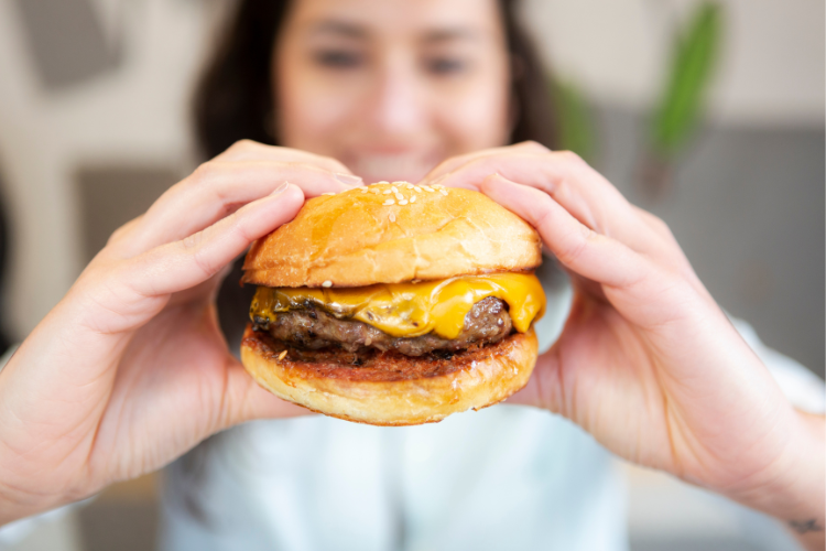 woman holding cheeseburger