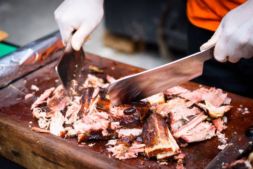 bbq being chopped on cutting board