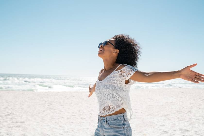 woman on beach with outstretched arms